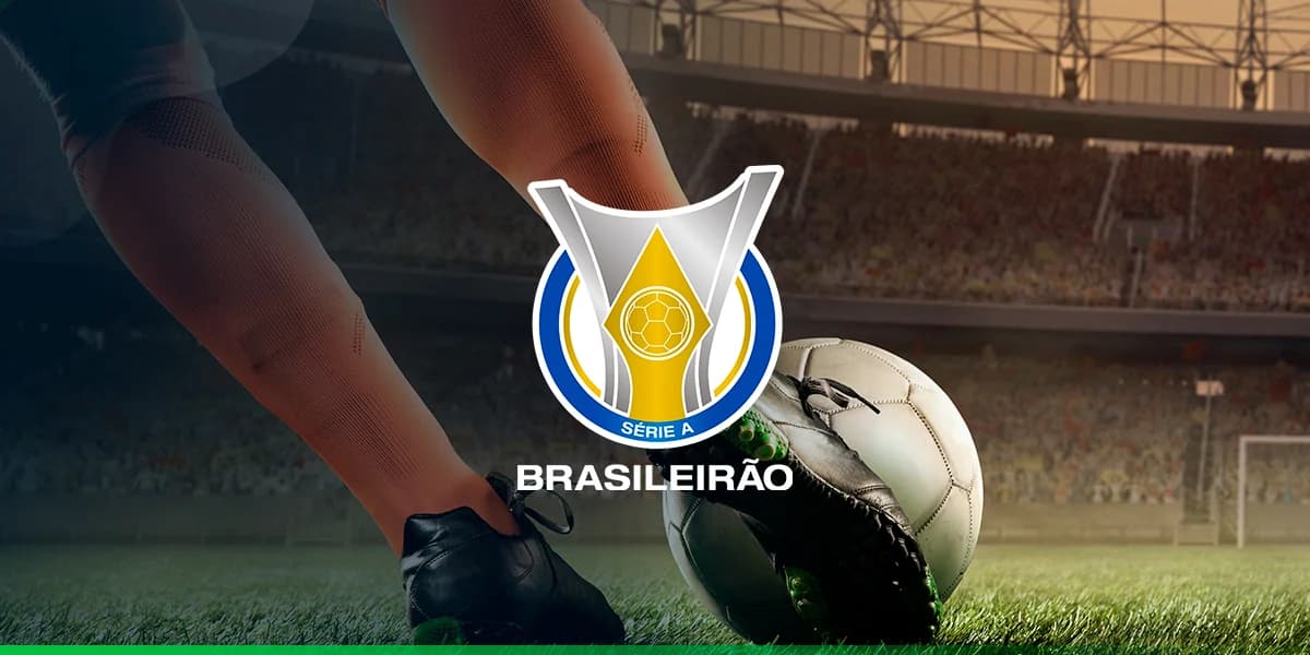 foto de dentro do campo de futebol em um estádio onde aparece apenas os pés do jogador chutando a bola