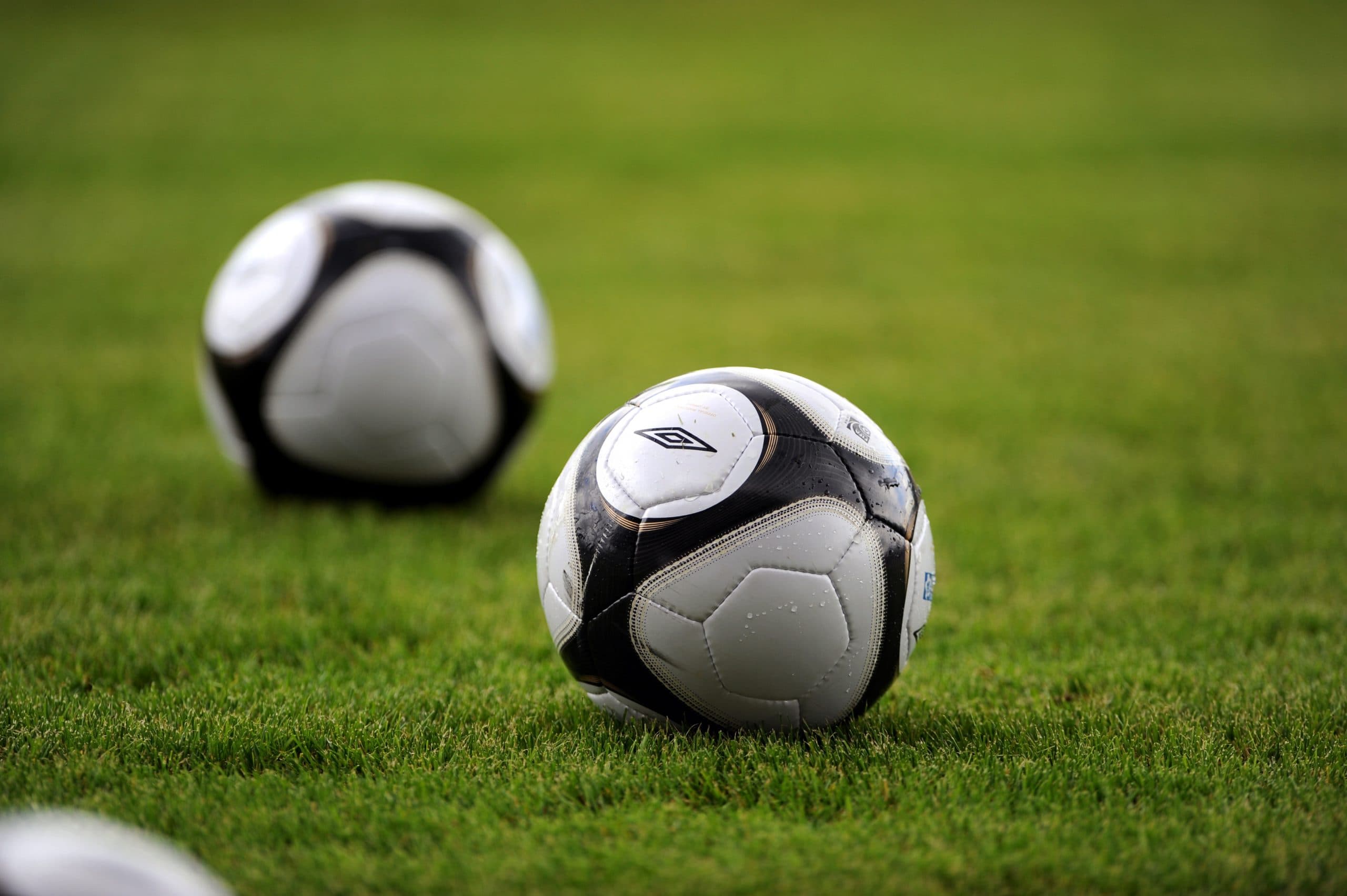 Duas bolas de futebol sobre o gramado
